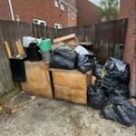 household rubbish and garden w old flat pack furniture, clothes and shoes in black bags , earth and grass clippings SE16